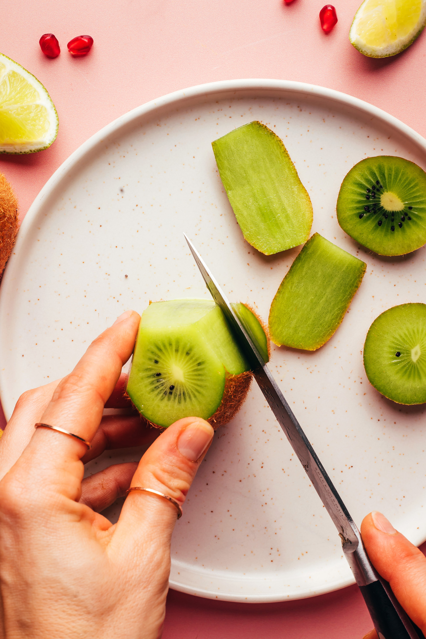 Slicing the peel off of a kiwi