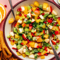 Serving spoons resting in a bowl of our easy winter fruit salad recipe