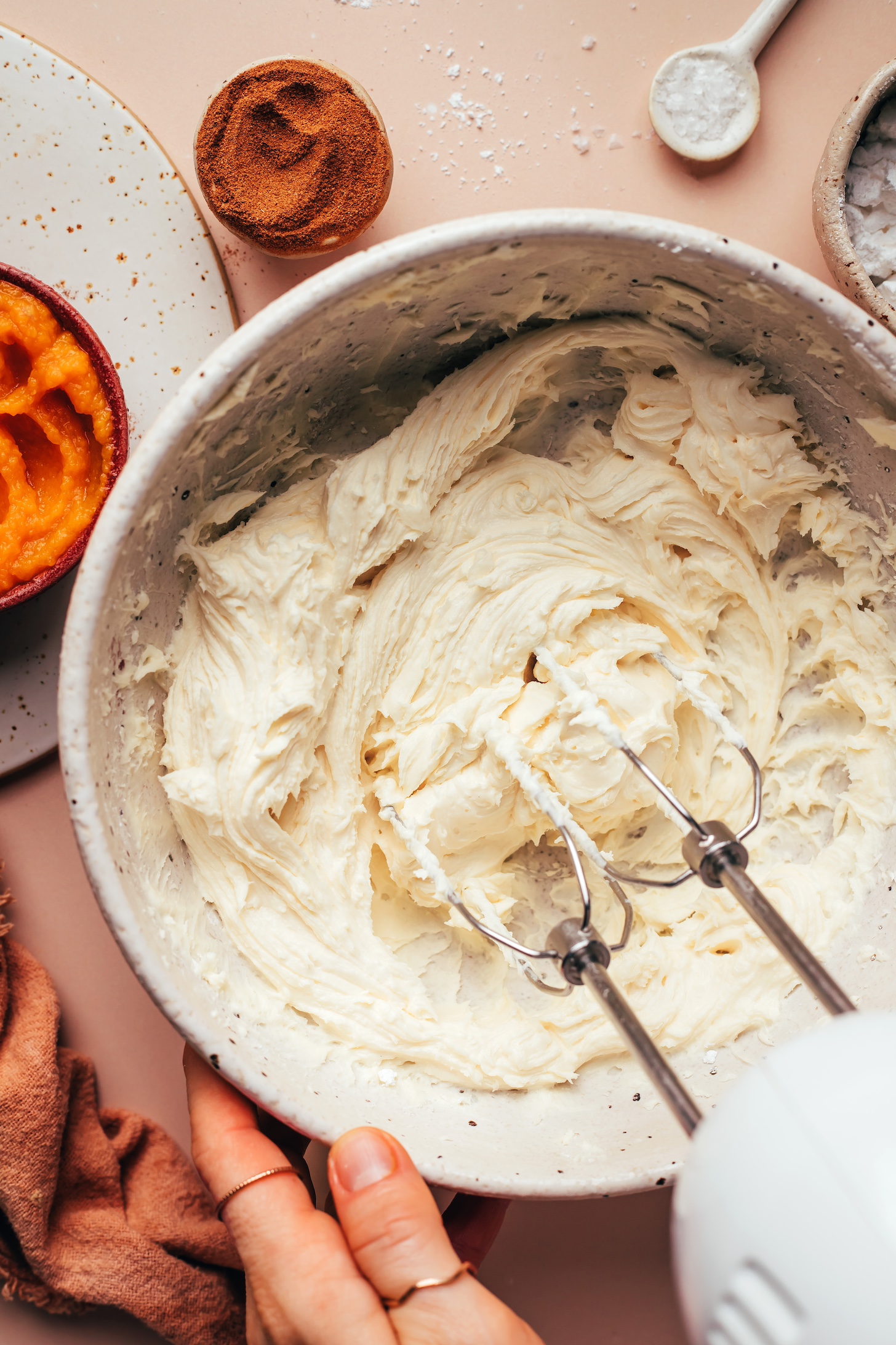 Using an electric mixer to whip vegan butter and powdered sugar