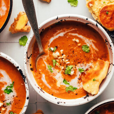 Bowls of our spicy pumpkin tomato soup with slices of vegan naan