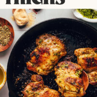 Cooking pesto baked chicken thighs in a cast iron skillet