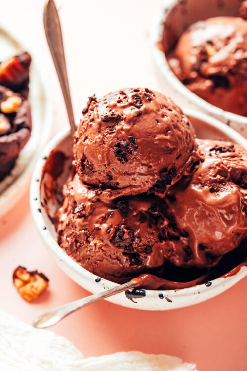Scoops of vegan chocolate brownie ice cream in a bowl with spoons