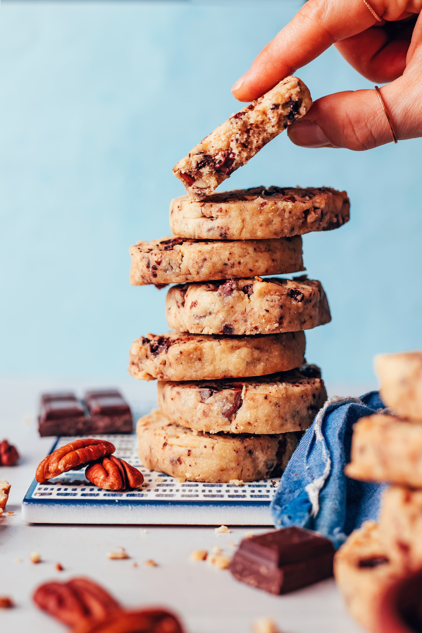 Picking up a shortbread cookie from a stack of more cookies