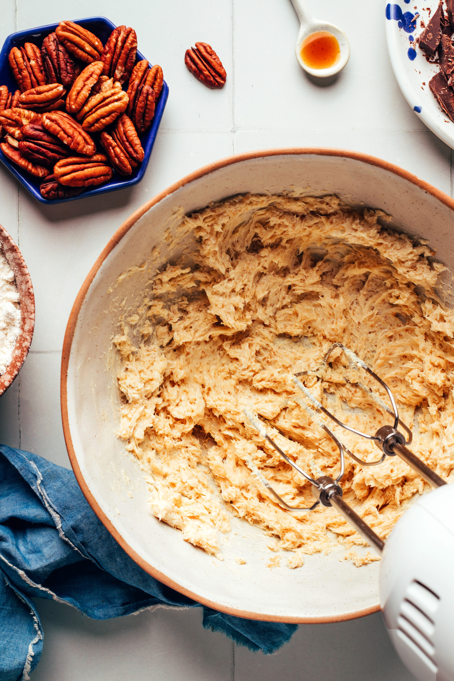 Hand mixer in a bowl of creamed vegan butter and cane sugar