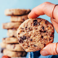 Holding up a vegan gluten-free chocolate chip pecan shortbread cookie