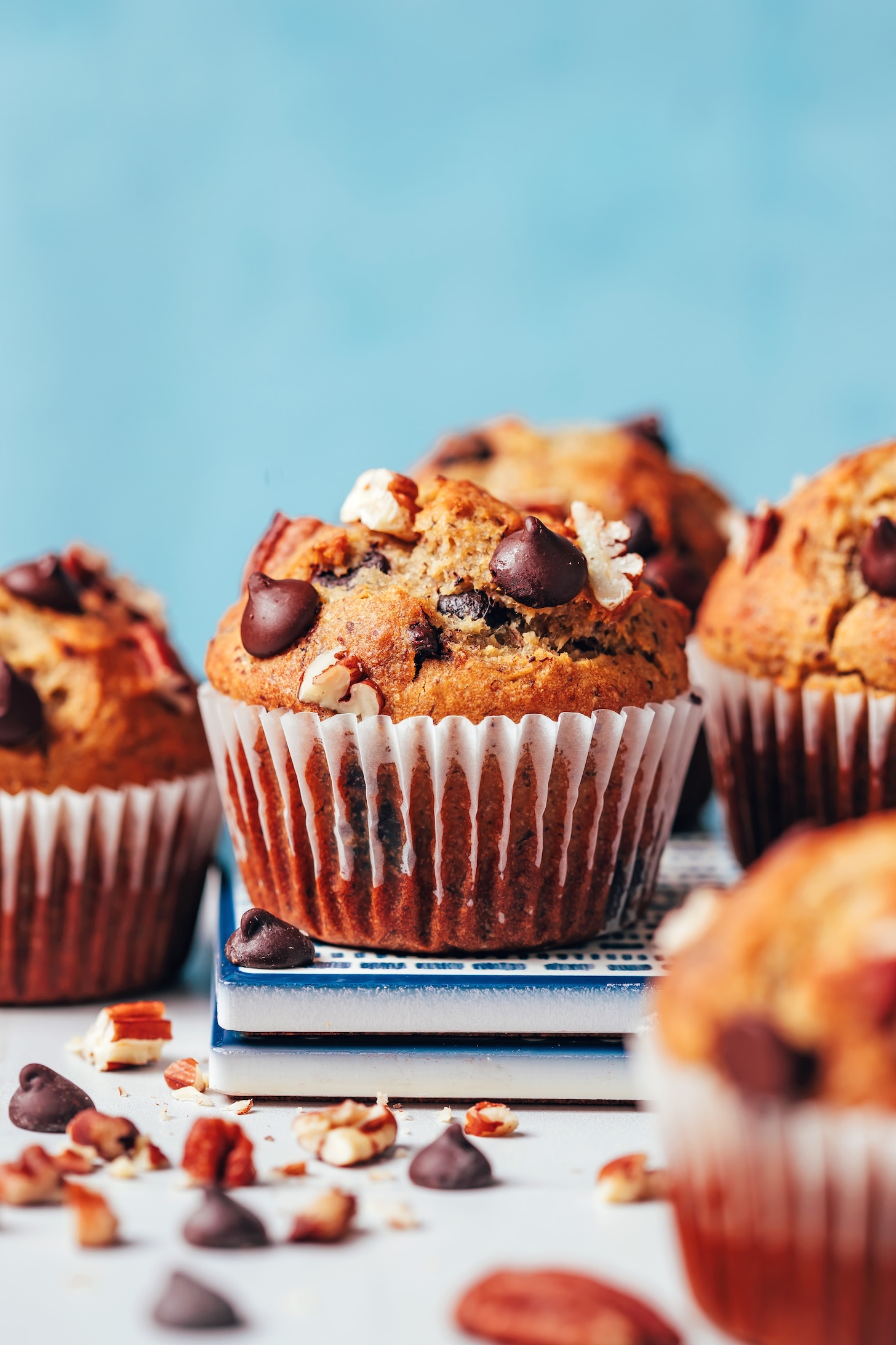 Vegan gluten-free banana chocolate chip muffins on a stack of tiles