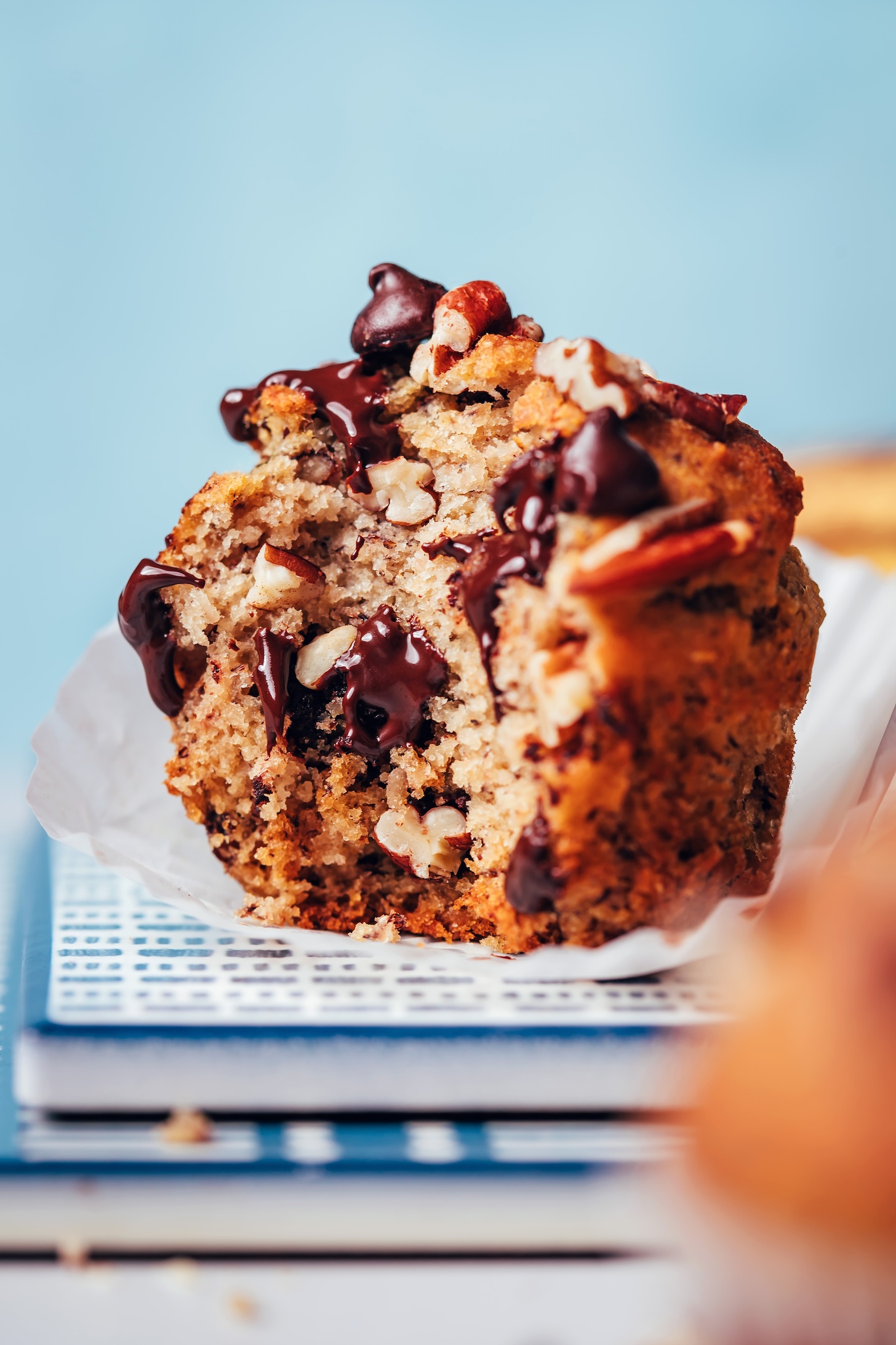 Partially eaten banana chocolate pecan muffin to show the fluffy texture and melty chocolate