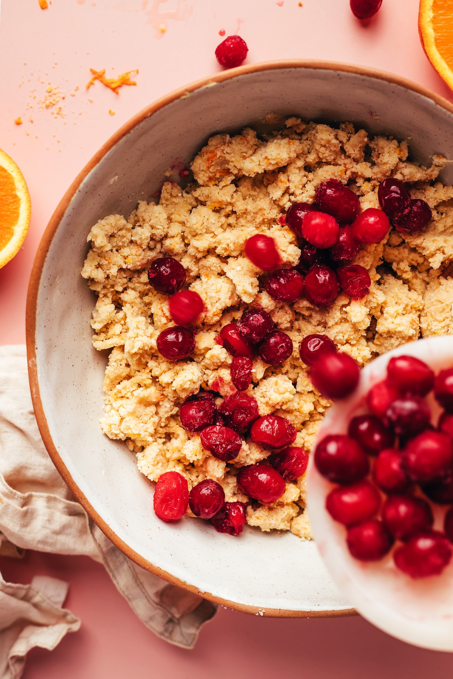 Pouring fresh cranberries into a bowl of scone dough