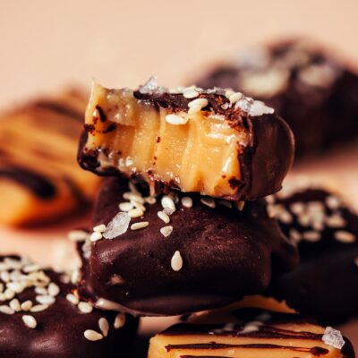 Stack of vegan sea salt caramels with some coated and some drizzled with dark chocolate