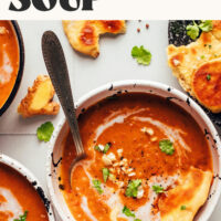 Bowls of our spicy pumpkin tomato soup recipe with text above them saying 1 pot and 30 minutes