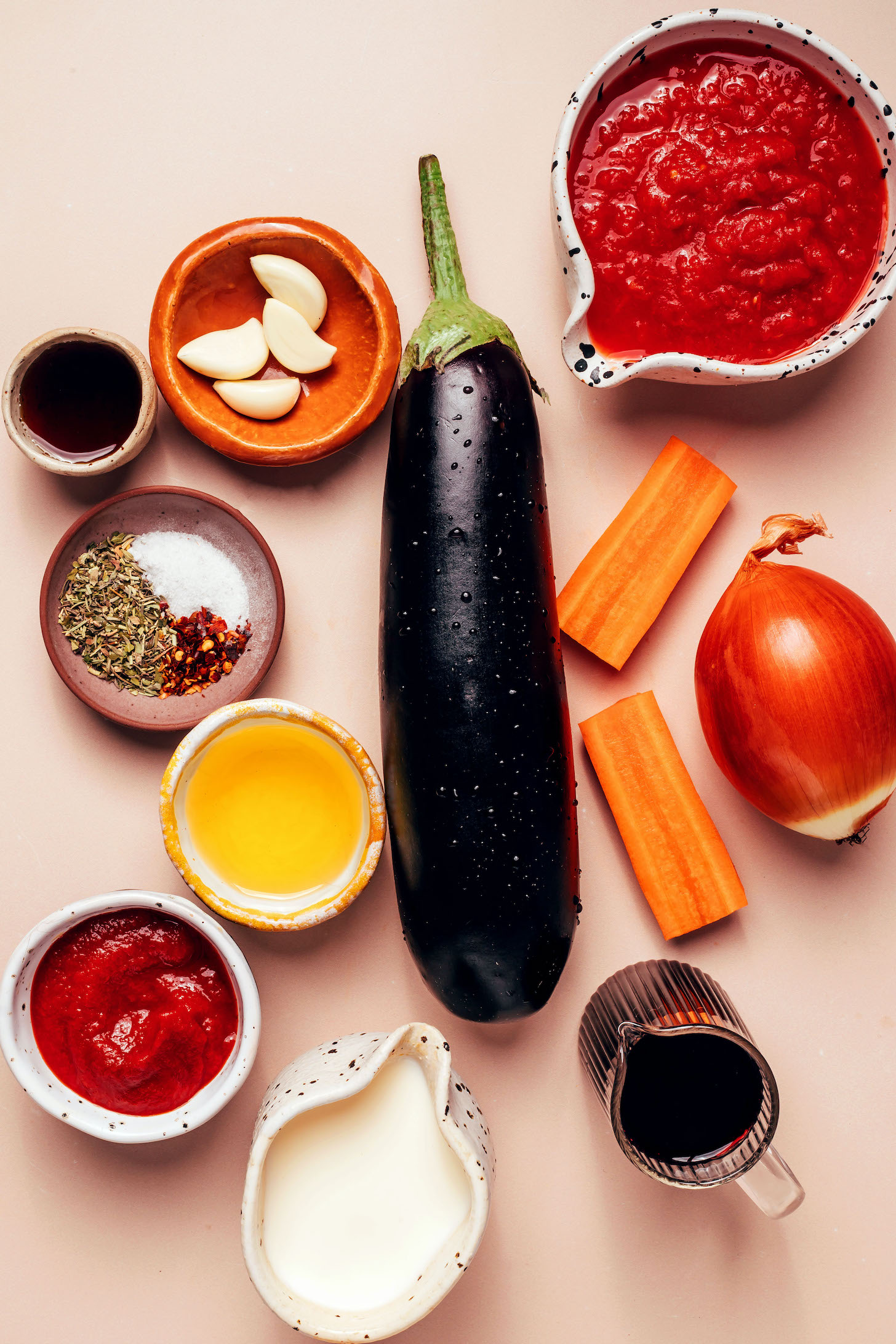Crushed tomatoes, eggplant, carrot, onion, red wine, cashew milk, tomato paste, olive oil, salt, red pepper flakes, dried Italian herbs, maple syrup, and garlic cloves