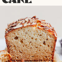 Photo of a partially sliced loaf of our 1-bowl gluten-free honey almond snack cake